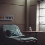 a-water-jug-and-glass-on-a-table-by-a-hospital-bed